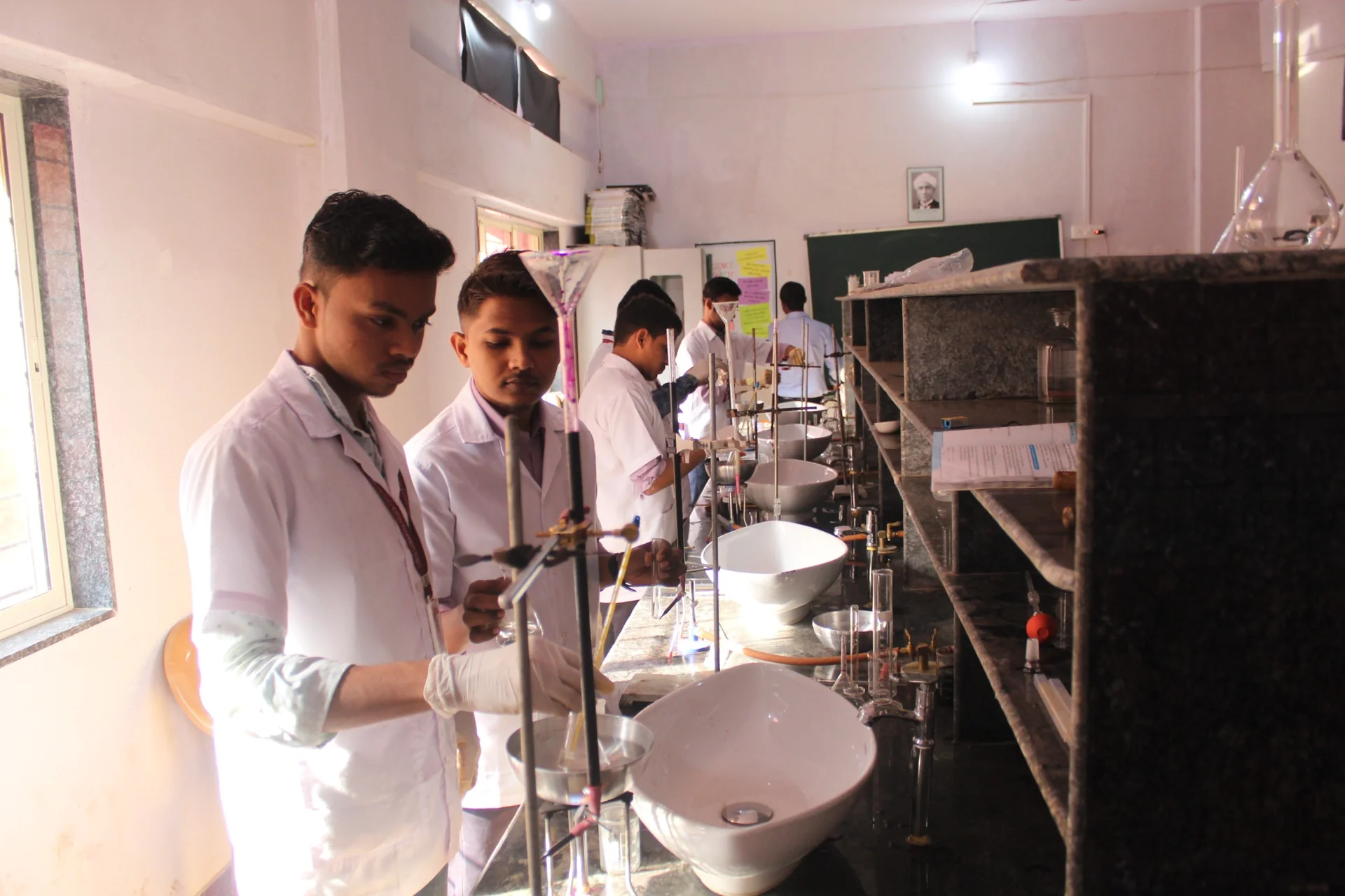 SSKEMS students in white laboratory coats working with science equipment.